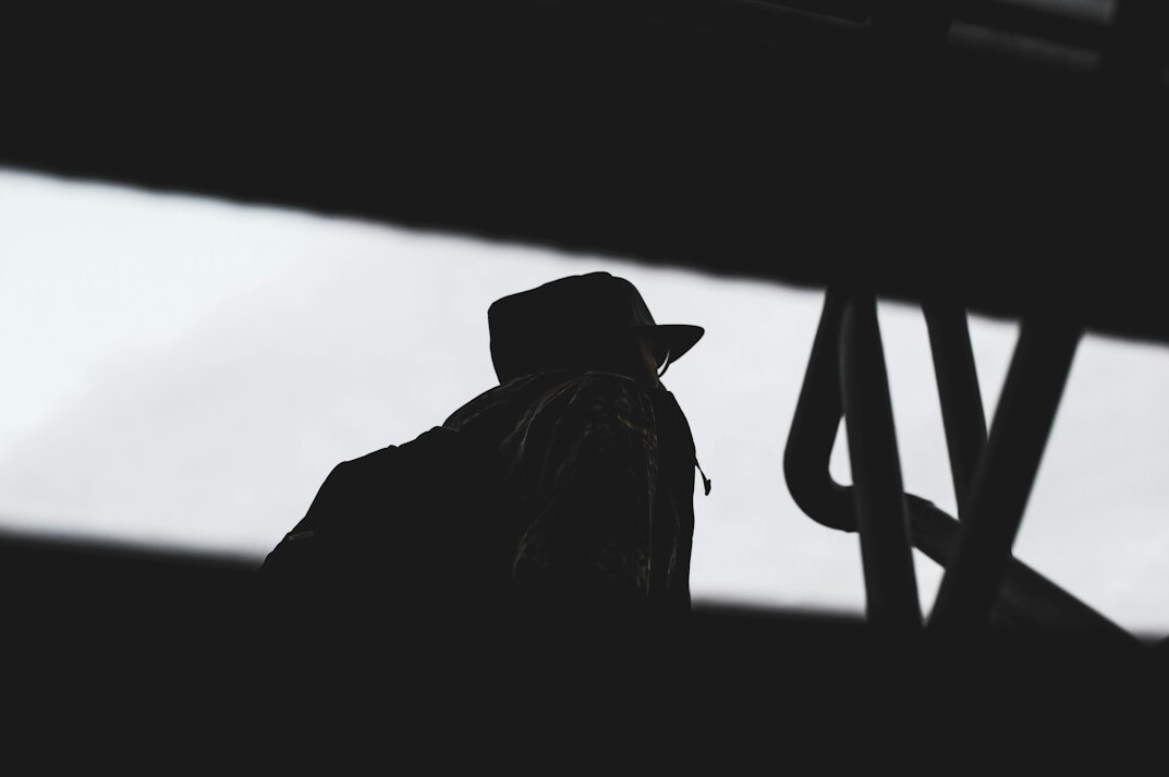 Noir style silhouette of a man wearing a hat and coat